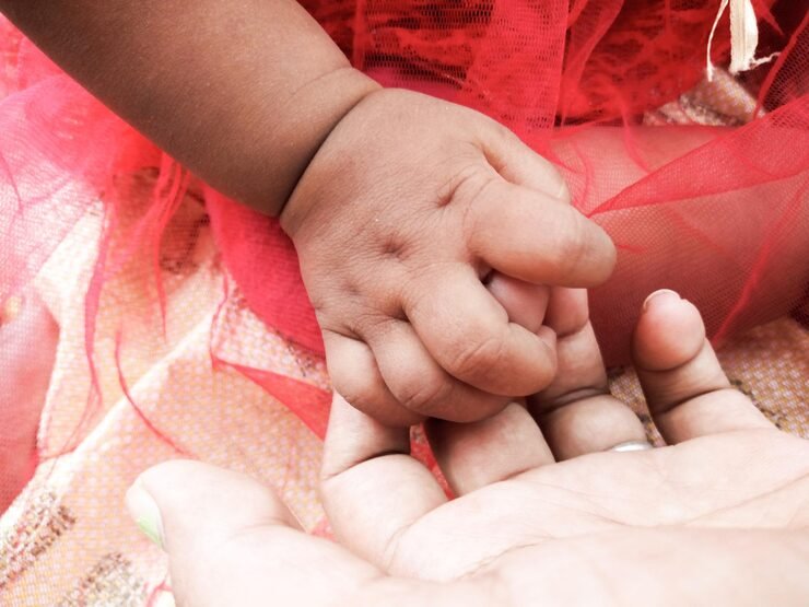 cropped-image-baby-girl-holding-mother-finger_1048944-1319071